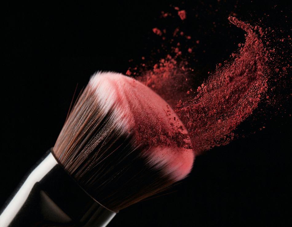 Пензель для макіяжу з розсипаною пудрою на чорному фоні — аксесуар для створення професійного мейкапу.